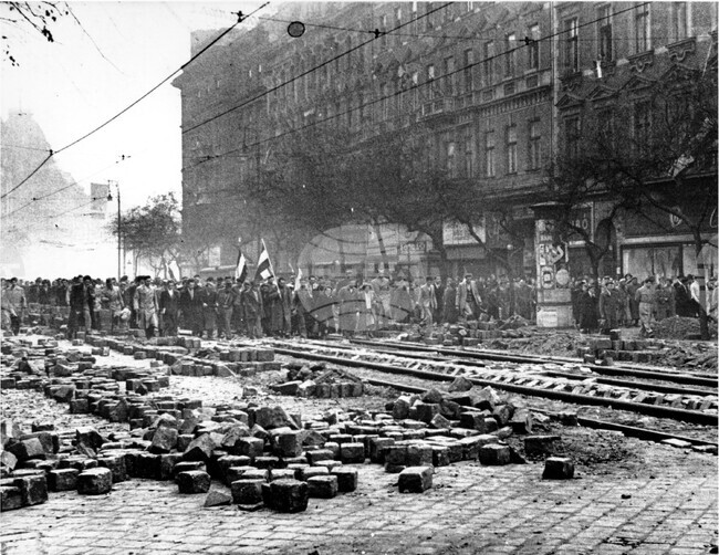 Будапеща, Унгария (октомври, 1956 г.) Антисъветски въстаници маршируват по „Ленин ринг“ по време на въстанието. Участниците в шествието са се събрали при паметника на Петьофи – герой от унгарското въстание през 1848 г. Паветата на улицата са изкъртени и разхвърляни. Антикомунистически настроените унгарски въстаници вече контролират градовете в Западна Унгария.